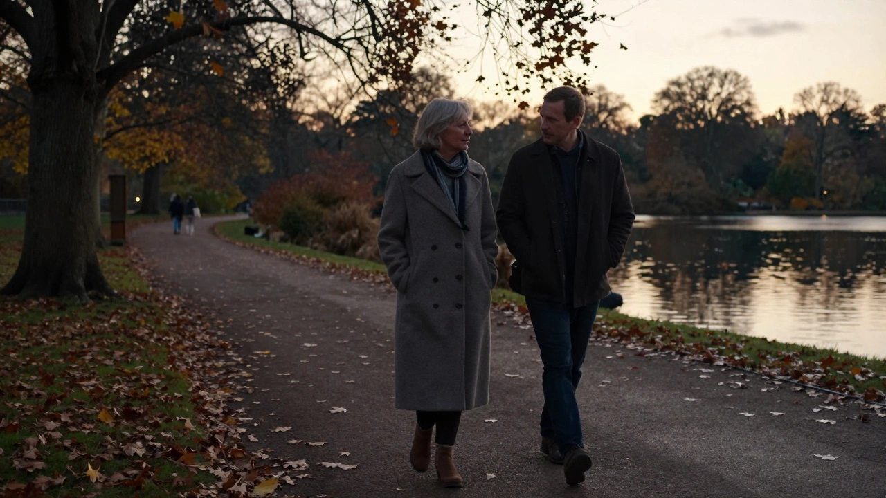 A woman and man walking peacefully through Hyde Park at dusk, autumn leaves falling around them.