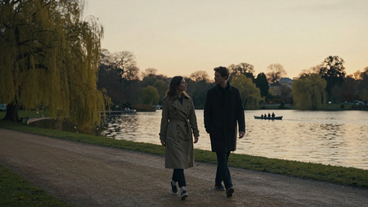 Silhouettes of a man and woman walking peacefully along a lake path in Hyde Park at sunset.