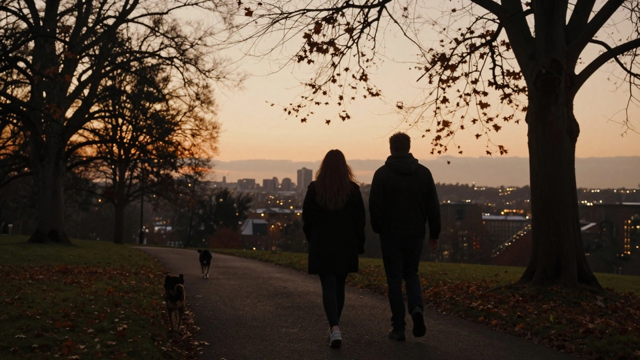 Two people walking peacefully along Primrose Hill at dusk, surrounded by autumn trees.